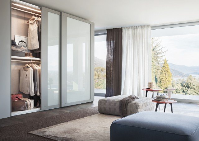 Riquadro si contraddistingue per il carattere forte, grazie alla grande cornice a fascia delle ante scorrevoli di legno laccato color Platino, in contrasto con la lucidità dei pannelli di vetro color Perla. Gli interni sono in tinta Lino, scenograficamente e soprattutto funzionalmente illuminati da lampade a incasso. Riquadro si contraddistingue per il carattere forte, grazie alla grande cornice a fascia delle ante scorrevoli di legno laccato color Platino, in contrasto con la lucidità dei pannelli di vetro color Perla. Gli interni sono in tinta Lino, scenograficamente e soprattutto funzionalmente illuminati da lampade a incasso.