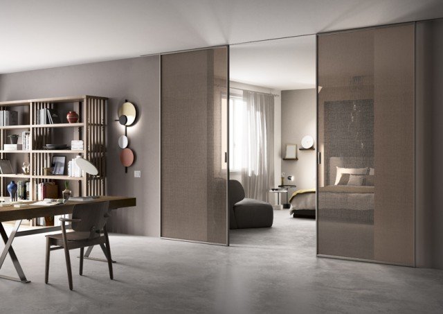 Il sistema di porte scorrevoli in vetro Scenario è qui proposto nel modello Delineo, con due ante scorrevoli, nella versione con scorrimento a incasso a soffitto, con profilo grigio perla e Cristallo Lino trasparente marrone, che ricorda la leggera matericità e trasparenza del tessuto. Dimensioni: anta da 120 x 270 cm. Il sistema di porte scorrevoli in vetro Scenario è qui proposto nel modello Delineo, con due ante scorrevoli, nella versione con scorrimento a incasso a soffitto, con profilo grigio perla e Cristallo Lino trasparente marrone, che ricorda la leggera matericità e trasparenza del tessuto. Dimensioni: anta da 120 x 270 cm.