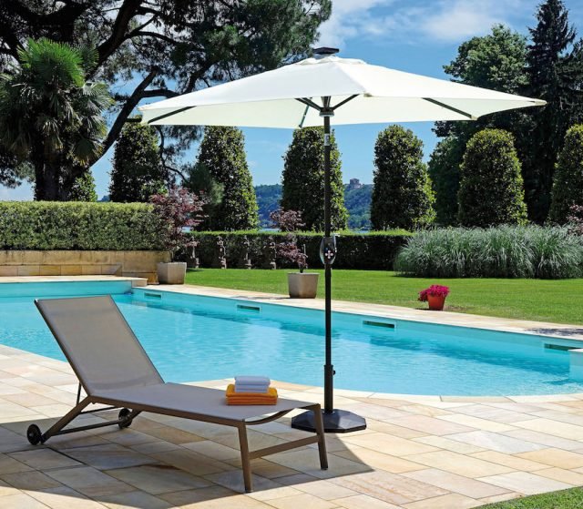 Ombrellone rotondo 5032 di Greenwood: fusto grigio antracite, palo con Ø 0,38 mm, 6 bacchette 14 x 20 mm in ferro con luci a led; luce centrale; connessione bluetooth con cassa integrata alimentata con panello solare. Misura n Ø 2,70 m, in poliestere 180gr colore ecrù; altezza max con base 2,50 mt. Costa 180 euro. (www.moiaspa.com/greenwood) Ombrellone rotondo 5032 di Greenwood: fusto grigio antracite, palo con Ø 0,38 mm, 6 bacchette 14 x 20 mm in ferro con luci a led; luce centrale; connessione bluetooth con cassa integrata alimentata con panello solare. Misura n Ø 2,70 m, in poliestere 180gr colore ecrù; altezza max con base 2,50 mt. Costa 180 euro. (www.moiaspa.com/greenwood)