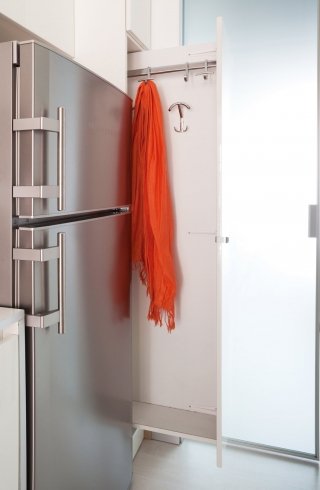 3. Appendiabiti a scorrimento. La composizione della cucina integra, a una delle estremità, un modulo da 30 cm estraibile e a scomparsa totale, attrezzato con ganci e appendiabiti.