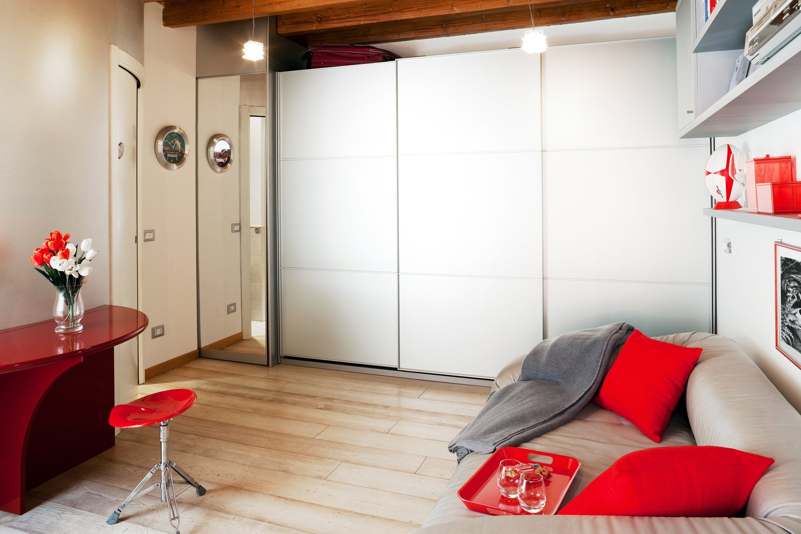 monolocale a Milano corso Como, zona giorno con divano grigio e armadio-parete bianco monolocale a Milano corso Como, zona giorno con divano grigio e armadio-parete bianco