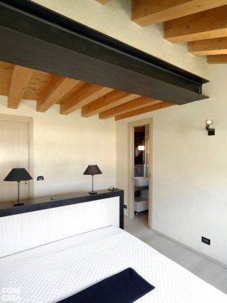 casa in legno e pietra, camera con letto al centro casa in legno e pietra, camera con letto al centro