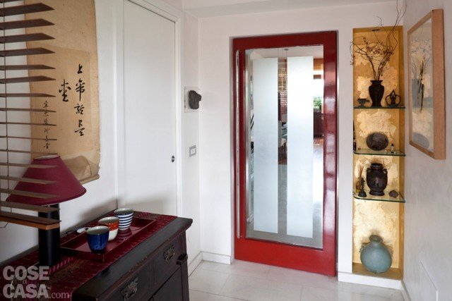L’ingresso è disimpegnato rispetto al soggiorno da una porta in vetro serigrafato; sulla sinistra, si accede invece al bagno. Lo spazio di passaggio è stato trasformato e reso più accogliente da pochi dettagli: come il rivestimento foglia oro delle nicchie che mettono in mostra oggetti di artigianato thailandese e vietnamita; o il mobile cinese del XIX secolo in laccato nero. L’ingresso è disimpegnato rispetto al soggiorno da una porta in vetro serigrafato; sulla sinistra, si accede invece al bagno. Lo spazio di passaggio è stato trasformato e reso più accogliente da pochi dettagli: come il rivestimento foglia oro delle nicchie che mettono in mostra oggetti di artigianato thailandese e vietnamita; o il mobile cinese del XIX secolo in laccato nero.