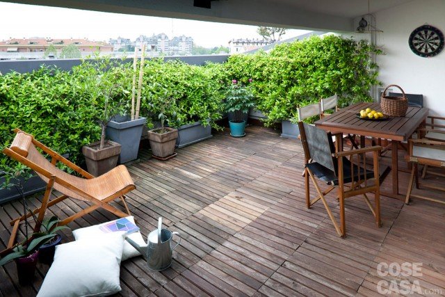 Il terrazzo, parzialmente coperto, si divide tra una zona pranzo riparata dalla tettoia e un’area relax soleggiata. A terra, i listelli in legno di teak sono stati posati con tecnica flottante, senza cioè incollarli o inchiodarli al massetto. Una composizione di piante in vaso nasconde il parapetto in cemento. Il terrazzo, parzialmente coperto, si divide tra una zona pranzo riparata dalla tettoia e un’area relax soleggiata. A terra, i listelli in legno di teak sono stati posati con tecnica flottante, senza cioè incollarli o inchiodarli al massetto. Una composizione di piante in vaso nasconde il parapetto in cemento.