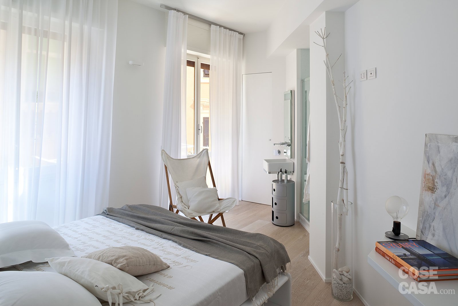 camera con letto tessile chiaro; la forma irregolare è quasi "annullata" visivamente dal total white   camera con letto tessile chiaro; la forma irregolare è quasi "annullata" visivamente dal total white
