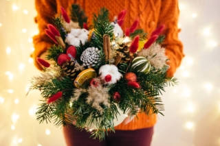 Christmas,Gift.,Woman,In,Orange,Sweater,Holding,A,Flower,Box