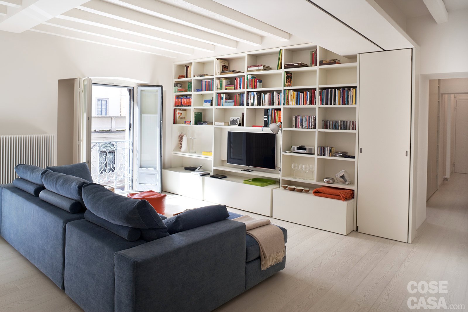 soggiorno divano blu libreria