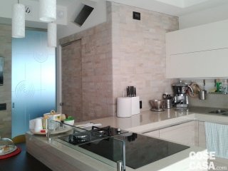 foto2_cucina con rivestimento in pietra e porta scorrevole tutto vetro tutta altezza