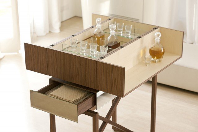 Nando di Porada è un'elegante soluzione salvaspazio per servire i drink in salotto. Base in massello di noce canaletta, contenitore esterno in noce canaletta e interno in acero. I cassetti sono rivestiti in specchio. Chiuso, misura L 90 x P 44 x H 131 cm. Prezzo su richiesta. www.porada.it Nando di Porada è un'elegante soluzione salvaspazio per servire i drink in salotto. Base in massello di noce canaletta, contenitore esterno in noce canaletta e interno in acero. I cassetti sono rivestiti in specchio. Chiuso, misura L 90 x P 44 x H 131 cm. Prezzo su richiesta. www.porada.it