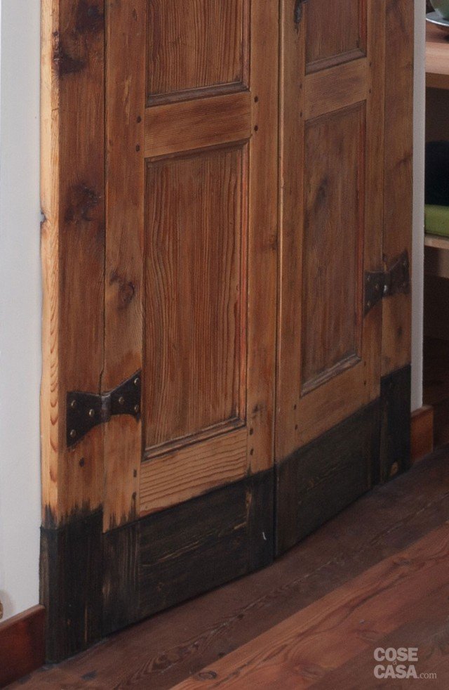 Il serramento che chiude il vano scala è originario: trattato e restaurato per riportare alla luce il suo aspetto, è stato anche oggetto di un piccolo ritocco. A seguito dell’intervento architettonico sulle quote interne, le due ante risultavano basse rispetto all’altezza dell’apertura: per allinearle, sono state aggiunte liste in legno nella parte inferiore, “invecchiandole” con olio per motori che ne ha macchiato e scurito la superficie. Il serramento che chiude il vano scala è originario: trattato e restaurato per riportare alla luce il suo aspetto, è stato anche oggetto di un piccolo ritocco. A seguito dell’intervento architettonico sulle quote interne, le due ante risultavano basse rispetto all’altezza dell’apertura: per allinearle, sono state aggiunte liste in legno nella parte inferiore, “invecchiandole” con olio per motori che ne ha macchiato e scurito la superficie.