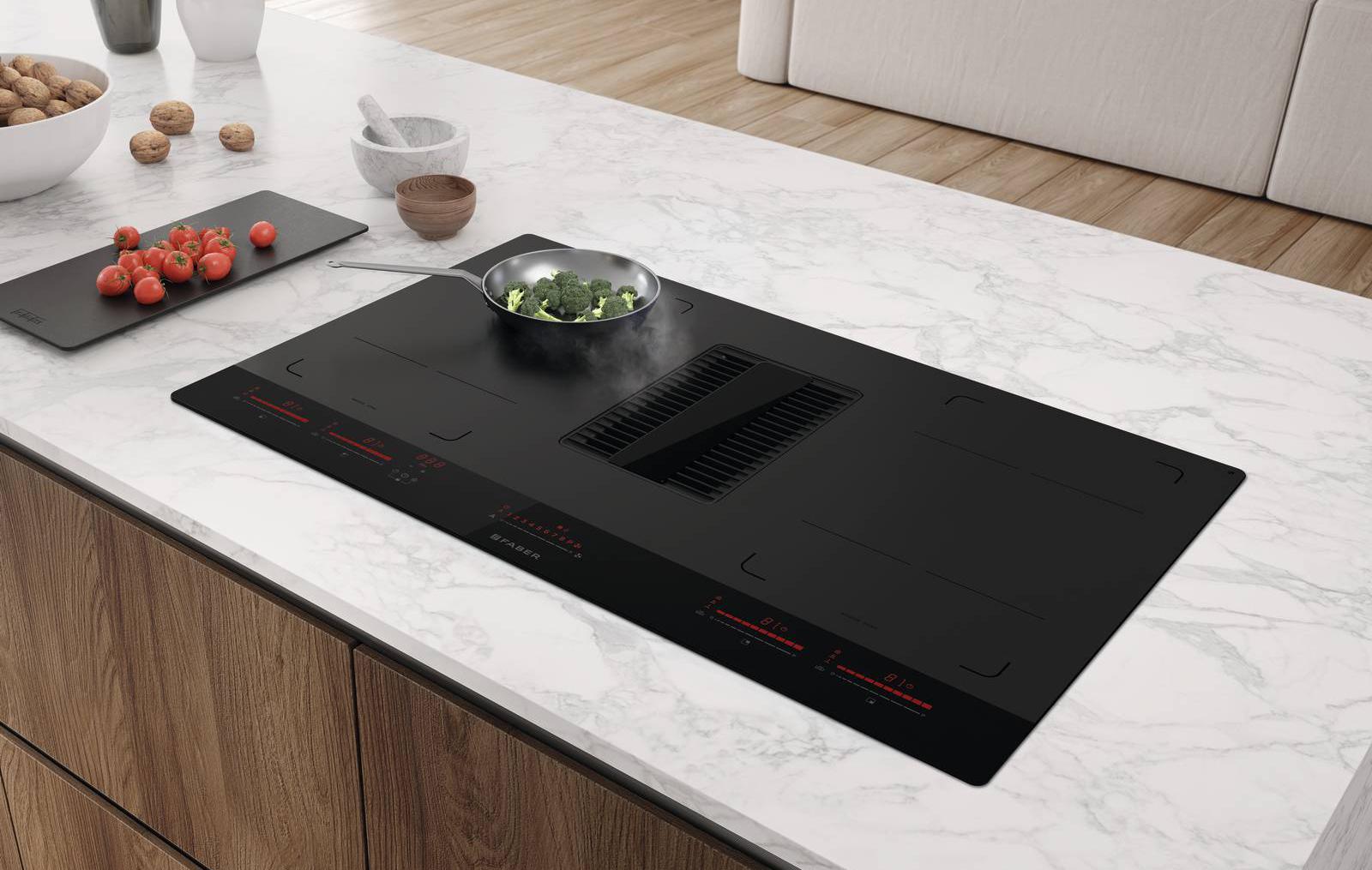 Il piano aspirante Galileo Glass di Faber combina finiture matt e glossy e si distingue per la cura dei dettagli e delle finiture, i comandi touch slider in vetro lucido e la zona cottura in vetro opaco piano, liscia e continua che consente di rimuovere lo sporco in un semplice passaggio. La griglia centrale ha dettaglio in vetro e risulta così più facile da pulire. Le diverse zone cottura sono attivabili in modalità combinata, così da poterle utilizzare insieme e con lo stesso livello di potenza. Misura 83 cm. Prezzo da rivenditore. www.faberspa.com