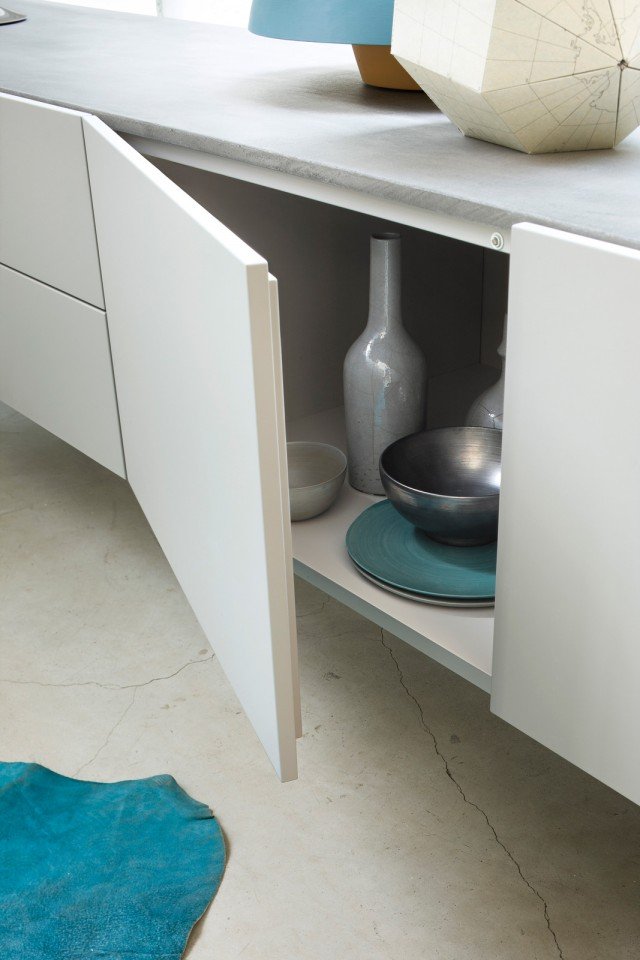 Le ante della madia bassa del sistema T030 (design Piero Lissoni) sono realizzate con profilo a mezza battuta, soluzione ottima per impedire alla polvere di entrare nei vani. Una cura dei dettagli che contraddistingue anche la ricerca sui materiali: questa madia, dal disegno estremamente minimale e geometrico, ha un top in cemento dalla forte valenza espressiva. Le ante della madia bassa del sistema T030 (design Piero Lissoni) sono realizzate con profilo a mezza battuta, soluzione ottima per impedire alla polvere di entrare nei vani. Una cura dei dettagli che contraddistingue anche la ricerca sui materiali: questa madia, dal disegno estremamente minimale e geometrico, ha un top in cemento dalla forte valenza espressiva.