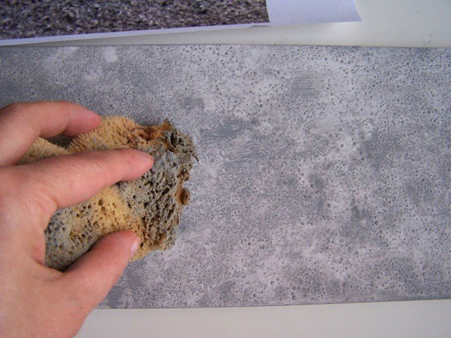 Con i colori acrilici create un grigio utilizzando due parti (per es. cucchiaini) di bianco e due di nero. Mescolate bene e diluite con poca acqua. Passate il colore su tutta la superficie con un pennello piatto e tamponate con una spugna umida prima che asciughi (Foto 3). Con i colori acrilici create un grigio utilizzando due parti (per es. cucchiaini) di bianco e due di nero. Mescolate bene e diluite con poca acqua. Passate il colore su tutta la superficie con un pennello piatto e tamponate con una spugna umida prima che asciughi (Foto 3).