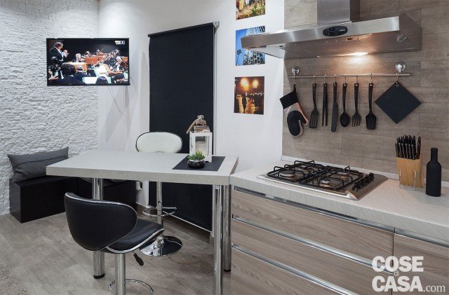 La composizione della cucina costituisce un blocco compatto all'interno dell'ambiente, anche sotto l'aspetto cromatico. Con un richiamo alla finitura dei mobili, la porzione di parete tra le basi e i pensili è protetta da piastrelle in gres effetto legno dello stesso tipo di quelle usate a pavimento (Nature Grey di Ceramica Sant'Agostino). La composizione della cucina costituisce un blocco compatto all'interno dell'ambiente, anche sotto l'aspetto cromatico. Con un richiamo alla finitura dei mobili, la porzione di parete tra le basi e i pensili è protetta da piastrelle in gres effetto legno dello stesso tipo di quelle usate a pavimento (Nature Grey di Ceramica Sant'Agostino).