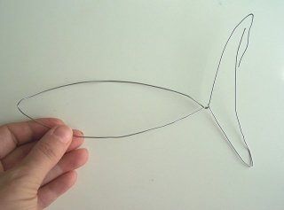 Prendete del filo di ferro e, con l’aiuto delle pinze, dategli la forma di un pesce stilizzato
