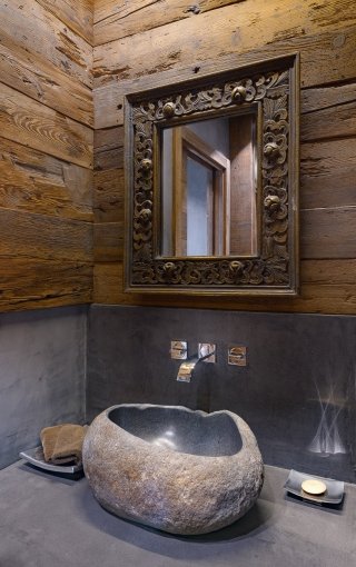 Mix di tradizione e di modernità anche per il bagno del piano principale, che al legno di larice antico della boiserie vede accostata la resina in tinta pietra per il rivestimento dei piani d’appoggio e il vano doccia. La cornice intagliata dello specchio e l’originale lavabo, ottenuto lavorando un blocco intero di pietra proveniente dall’Indonesia, aggiungono carattere all’ambiente, personalizzandolo e denotandolo in modo deciso. Mix di tradizione e di modernità anche per il bagno del piano principale, che al legno di larice antico della boiserie vede accostata la resina in tinta pietra per il rivestimento dei piani d’appoggio e il vano doccia. La cornice intagliata dello specchio e l’originale lavabo, ottenuto lavorando un blocco intero di pietra proveniente dall’Indonesia, aggiungono carattere all’ambiente, personalizzandolo e denotandolo in modo deciso.