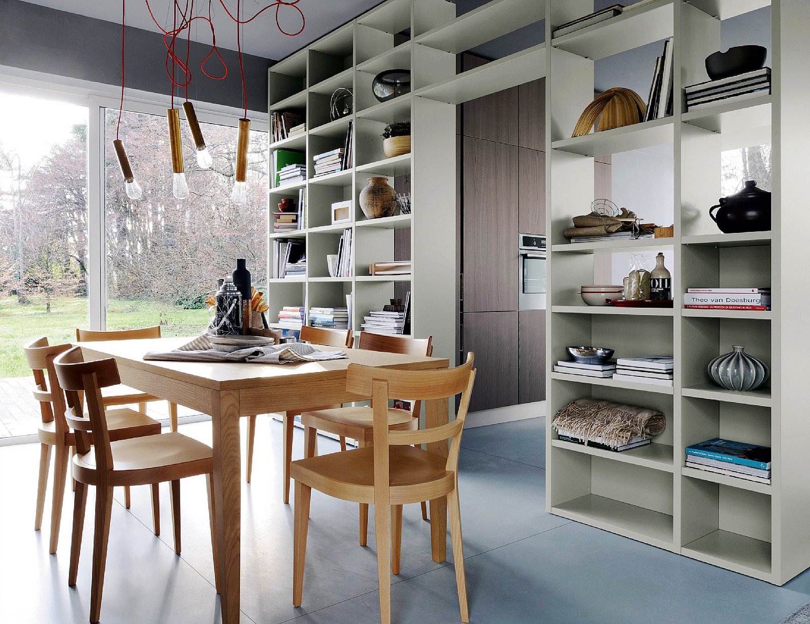 Libreria a ponte che scherma la cucina, pensata come spazio per cucinare e contenere, e allo stesso tempo la connette alla zona pranzo. Libreria a ponte che scherma la cucina, pensata come spazio per cucinare e contenere, e allo stesso tempo la connette alla zona pranzo.