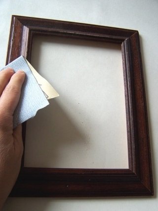 Carteggiate la cornice con la carta vetrata e spolverate con un panno