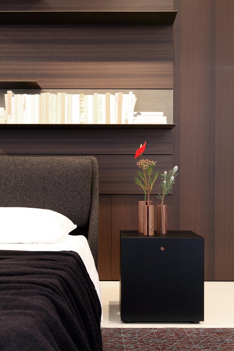 Il letto Makura di Piero Lissoni, leggermente sospeso dalla forma invitante e accogliente, impreziosito da cuscini tessuto e rivestimenti in pelle o tessuto, sempre nello showroom Porro.
