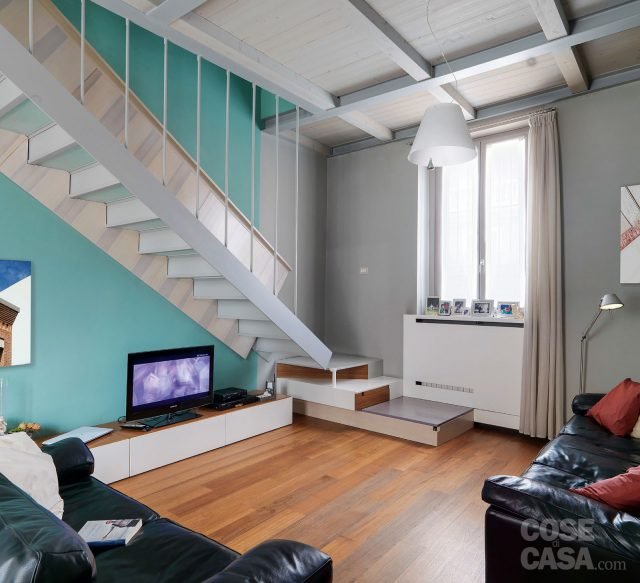 Scala a giorno che si staglia in modo evidente sullo sfondo colorato, a contrasto, della parete Scala a giorno che si staglia in modo evidente sullo sfondo colorato, a contrasto, della parete