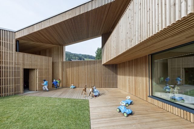 L’asilo nido Valdaora si integra nell’ambiente circostante con la massima naturalezza e disinvoltura, senza alcuna subordinazione, recuperando e prendendo a modello le qualità spaziali del piccolo paese di Valdaora di Sotto. Feld72 Architekten L’asilo nido Valdaora si integra nell’ambiente circostante con la massima naturalezza e disinvoltura, senza alcuna subordinazione, recuperando e prendendo a modello le qualità spaziali del piccolo paese di Valdaora di Sotto. Feld72 Architekten