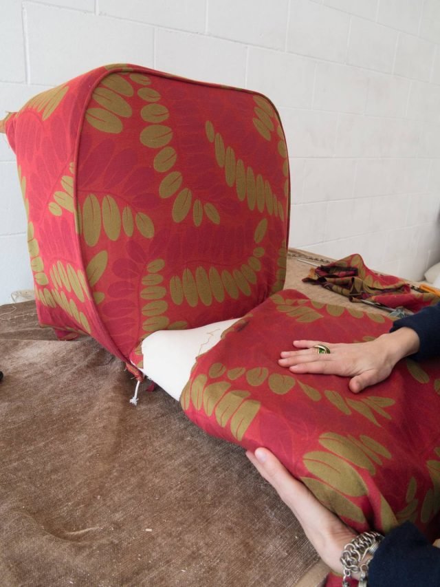 Appoggiare allo schienale un pezzo
di stoffa, ripiegarlo sul
retro, fare due tagli verticali lungo il bordo inferiore e inserire la stoffa in eccesso
tra la seduta e lo schienale. Appoggiare allo schienale un pezzo
di stoffa, ripiegarlo sul
retro, fare due tagli verticali lungo il bordo inferiore e inserire la stoffa in eccesso
tra la seduta e lo schienale.