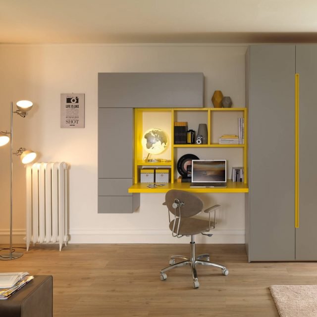 Una soluzione bella e luminosa che va bene sia per lo studio che per il lavoro. Questo si realizza grazie ai wallbox che compongono la zona studio di fianco all’armadio e che incorniciano una piccola libreria Outline. Il piano scrivania è completamente laccato e trattato con strato protettivo UV. Alzarsi e aprire il wallbox in altezza diventa facile e comodo grazie all’apertura basculante. (FOTO: YOUNG_YC308_P3) Una soluzione bella e luminosa che va bene sia per lo studio che per il lavoro. Questo si realizza grazie ai wallbox che compongono la zona studio di fianco all’armadio e che incorniciano una piccola libreria Outline. Il piano scrivania è completamente laccato e trattato con strato protettivo UV. Alzarsi e aprire il wallbox in altezza diventa facile e comodo grazie all’apertura basculante. (FOTO: YOUNG_YC308_P3)