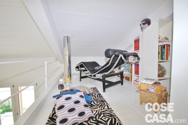 Sul soppalco, nella zona relax: chaise longue di Cassina e librerie su misura che seguono l'andamento del soffitto, in parte a giorno e in parte chiuse; tappeto zebrato. Sul soppalco, nella zona relax: chaise longue di Cassina e librerie su misura che seguono l'andamento del soffitto, in parte a giorno e in parte chiuse; tappeto zebrato.