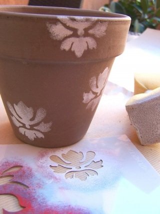 Iniziate a riempire lo stencil in modo non uniforme per creare delle sfumature. Procedete così per tutta la superficie del vaso, spostando lo stencil di volta in volta Iniziate a riempire lo stencil in modo non uniforme per creare delle sfumature. Procedete così per tutta la superficie del vaso, spostando lo stencil di volta in volta