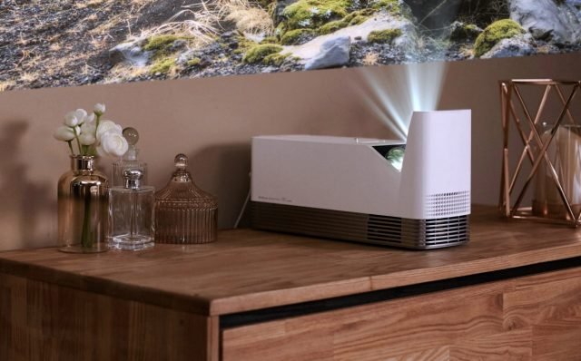 Il proiettore HF85JA di LG è un proiettore Full HD (1080p) caratterizzato da un’ottica a tiro ultra-corto per una immersiva esperienza home cinema. I proiettori con ottica a tiro ultra-corto non hanno necessità di un’installazione professionale e non hanno bisogno di ingombranti e antiestetici cavi o ampio spazio fra il proiettore e lo schermo. Questo modello richiede solo 12 cm dalla parete per fornire un’immagine con diagonale da 100”. Genera fino a 1.500 ANSI lumen, ed è 1,5 volte più luminoso rispetto al precedente proiettore UST di LG. Il rapporto di contrasto 150.000:1 garantisce che ogni film o spettacolo televisivo proiettato apparirà nitido e definito. In aggiunta, la sorgente luminosa di questo proiettore dispone di un’elevata durata, stimata fino a 20.000 ore. www.lg.com Il proiettore HF85JA di LG è un proiettore Full HD (1080p) caratterizzato da un’ottica a tiro ultra-corto per una immersiva esperienza home cinema. I proiettori con ottica a tiro ultra-corto non hanno necessità di un’installazione professionale e non hanno bisogno di ingombranti e antiestetici cavi o ampio spazio fra il proiettore e lo schermo. Questo modello richiede solo 12 cm dalla parete per fornire un’immagine con diagonale da 100”. Genera fino a 1.500 ANSI lumen, ed è 1,5 volte più luminoso rispetto al precedente proiettore UST di LG. Il rapporto di contrasto 150.000:1 garantisce che ogni film o spettacolo televisivo proiettato apparirà nitido e definito. In aggiunta, la sorgente luminosa di questo proiettore dispone di un’elevata durata, stimata fino a 20.000 ore. www.lg.com