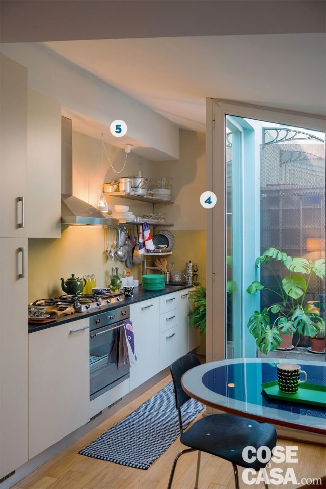 La composizione della cucina, sviluppata in linea su una sola parete, sfrutta la zona in cui l’ambiente si restringe, in corrispondenza della vetrata del terrazzo.
È stato comunque possibile inserire basi di profondità standard, lasciando una striscia per il passaggio ampia circa 60 cm. Nella zona cottura la composizione (di Cesar Cucine) che si sviluppa lungo la parete è in laccato bianco opaco con piano di lavoro in ardesia. La cappa, il piano cottura a gas e il forno hanno estetica inox spazzolato, come le mensole sulla destra.
4. La vetrata che fa angolo
Il serramento in alluminio si articola su due lati per illuminare sia la zona cottura sia il tavolo da pranzo, con vetrate a tutta altezza in vetro stratificato (realizzate su disegno per seguire l’inclinazione del tetto). L’apertura è però soltanto verso il living, perché dalla parte della cucina ostacolerebbe il passaggio.
5. La veletta in cucina
Una fascia di ribassamento in cartongesso completa, in alto, la composizione della cucina con funzione di tamponamento tra pensili e soffitto. Serve inoltre a contenere i cavi elettrici dei corpi illuminanti. La composizione della cucina, sviluppata in linea su una sola parete, sfrutta la zona in cui l’ambiente si restringe, in corrispondenza della vetrata del terrazzo.
È stato comunque possibile inserire basi di profondità standard, lasciando una striscia per il passaggio ampia circa 60 cm. Nella zona cottura la composizione (di Cesar Cucine) che si sviluppa lungo la parete è in laccato bianco opaco con piano di lavoro in ardesia. La cappa, il piano cottura a gas e il forno hanno estetica inox spazzolato, come le mensole sulla destra.
4. La vetrata che fa angolo
Il serramento in alluminio si articola su due lati per illuminare sia la zona cottura sia il tavolo da pranzo, con vetrate a tutta altezza in vetro stratificato (realizzate su disegno per seguire l’inclinazione del tetto). L’apertura è però soltanto verso il living, perché dalla parte della cucina ostacolerebbe il passaggio.
5. La veletta in cucina
Una fascia di ribassamento in cartongesso completa, in alto, la composizione della cucina con funzione di tamponamento tra pensili e soffitto. Serve inoltre a contenere i cavi elettrici dei corpi illuminanti.