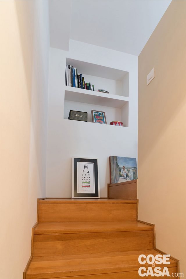 La rampa lineare, con gradini rivestiti in legno di teak, parte dal disimpegno al piano d’ingresso e porta al livello superiore dove si trovano la camera e il terrazzo. La rampa lineare, con gradini rivestiti in legno di teak, parte dal disimpegno al piano d’ingresso e porta al livello superiore dove si trovano la camera e il terrazzo.