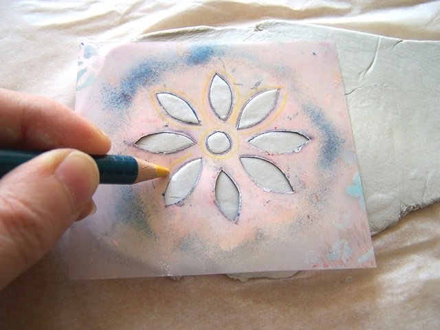Prendete lo stencil e poggiatelo sul pasta da modellare. Con una matita ripassare i bordi dello stencil, per far fuoriuscire la pasta dai fori e rendere il decoro più in rilievo. Prendete lo stencil e poggiatelo sul pasta da modellare. Con una matita ripassare i bordi dello stencil, per far fuoriuscire la pasta dai fori e rendere il decoro più in rilievo.