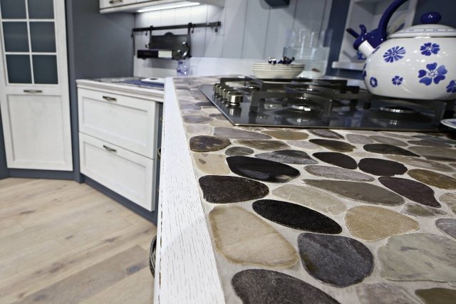 Eva di Arrex è la cucina con il top extra realizzato in ciottoli di fiume levigati a mano racchiusi da un bordo in legno massiccio sagomato: il risultato è una superficie originale e molto decorativa. Le ante sono in legno laccato nella finitura Shabby Chic e si alternano ai muretti in pittura Sacile Graf colore Mirtillo. Un modulo base misura L 60 x P 58 x H 72 cm. Prezzo 292,80 euro. www.arrex.it Eva di Arrex è la cucina con il top extra realizzato in ciottoli di fiume levigati a mano racchiusi da un bordo in legno massiccio sagomato: il risultato è una superficie originale e molto decorativa. Le ante sono in legno laccato nella finitura Shabby Chic e si alternano ai muretti in pittura Sacile Graf colore Mirtillo. Un modulo base misura L 60 x P 58 x H 72 cm. Prezzo 292,80 euro. www.arrex.it