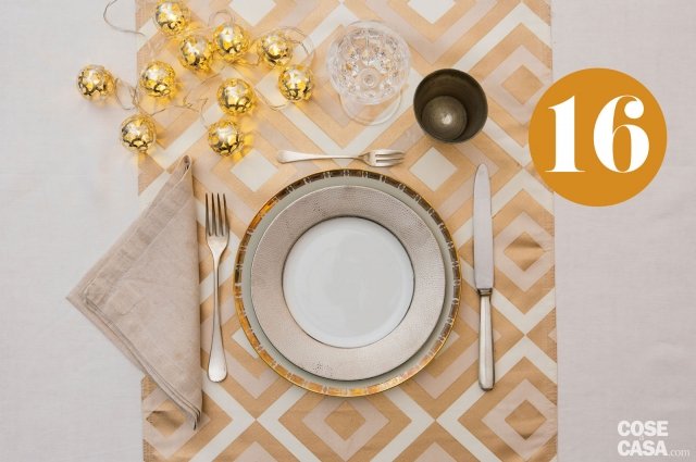 Oro e argento per la tavola di Natale grafica ed elegante. Sulla tovaglia bianca in fiandra di lino un runner a motivi geometrici in nuance dove scegliere piatti con bordi lavorati, in oro zecchino e argento, effetto pelle di rettile. Posate di linea contemporanea, calice di cristallo, bicchiere in silver e un pizzico di magia con le boule a led (con batteria). Oro e argento per la tavola di Natale grafica ed elegante. Sulla tovaglia bianca in fiandra di lino un runner a motivi geometrici in nuance dove scegliere piatti con bordi lavorati, in oro zecchino e argento, effetto pelle di rettile. Posate di linea contemporanea, calice di cristallo, bicchiere in silver e un pizzico di magia con le boule a led (con batteria).