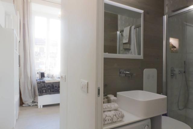 (foto8) Il bagno, posizionato all’ingresso della casa per potenziarne la superficie e lasciare piena visuale alla finestra, sfrutta come rivestimento verticale le medesime plance del parquet. Il disegno su misura degli arredi e un grande specchio ne potenziano lo sfruttamento funzionale oltre che la percezione ottica e la luminosità. (foto8) Il bagno, posizionato all’ingresso della casa per potenziarne la superficie e lasciare piena visuale alla finestra, sfrutta come rivestimento verticale le medesime plance del parquet. Il disegno su misura degli arredi e un grande specchio ne potenziano lo sfruttamento funzionale oltre che la percezione ottica e la luminosità.