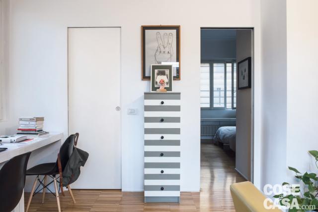 Nel passaggio tra la zona giorno e parte notte, in corrispondenza della doppia postazione studio, le due porte gemelle con sistema di scorrimento interno muro e maniglie incassate chiudono i due ambienti adiacenti del bagno e della camera da letto: i serramenti, rifiniti in una gradazione di bianco che si avvicina a quella dei muri, hanno un impatto visivo assolutamente discreto. Nella simmetria che caratterizza la parete si inserisce, al centro, il settimanale slanciato in verticale, rivisitato da una nuova smaltatura a fasce orizzontali in bianco e grigio. Nel passaggio tra la zona giorno e parte notte, in corrispondenza della doppia postazione studio, le due porte gemelle con sistema di scorrimento interno muro e maniglie incassate chiudono i due ambienti adiacenti del bagno e della camera da letto: i serramenti, rifiniti in una gradazione di bianco che si avvicina a quella dei muri, hanno un impatto visivo assolutamente discreto. Nella simmetria che caratterizza la parete si inserisce, al centro, il settimanale slanciato in verticale, rivisitato da una nuova smaltatura a fasce orizzontali in bianco e grigio.