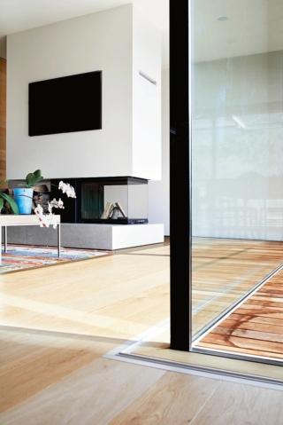 Il camino riprende nella struttura il gioco dei volumi aperti e chiusi (in alto) e delimita questa parte del living creando un effetto parete (in basso). In legno il tavolo da pranzo d'epoca.