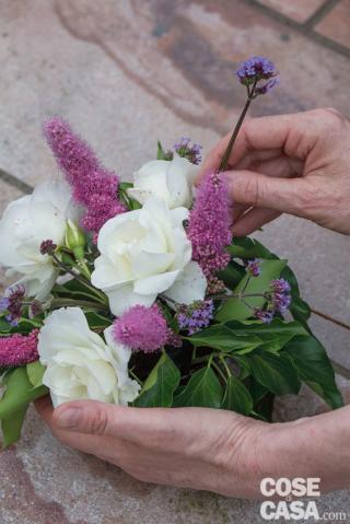 7. Completare inserendo Achillea millefolium e Verbena bonariensis tra le rose e la spirea per donare un tocco di leggerezza; per richiamare e sottolineare le tonalità rosate dei fiori, si possono inserire rametti di Lysimachia. Attendere qualche minuto e fare ruotare ogni coppetta, osservarla per verificare la buona distribuzione di rose, fiori e foglie: non devono esserci vuoti e il peso ottico dei vari elementi deve risultare calibrato. 7. Completare inserendo Achillea millefolium e Verbena bonariensis tra le rose e la spirea per donare un tocco di leggerezza; per richiamare e sottolineare le tonalità rosate dei fiori, si possono inserire rametti di Lysimachia. Attendere qualche minuto e fare ruotare ogni coppetta, osservarla per verificare la buona distribuzione di rose, fiori e foglie: non devono esserci vuoti e il peso ottico dei vari elementi deve risultare calibrato.