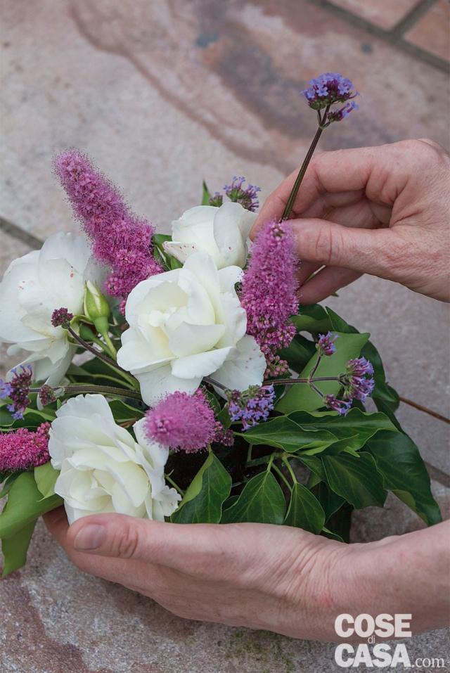 7. Completare inserendo Achillea millefolium e Verbena bonariensis tra le rose e la spirea per donare un tocco di leggerezza; per richiamare e sottolineare le tonalità rosate dei fiori, si possono inserire rametti di Lysimachia. Attendere qualche minuto e fare ruotare ogni coppetta, osservarla per verificare la buona distribuzione di rose, fiori e foglie: non devono esserci vuoti e il peso ottico dei vari elementi deve risultare calibrato. 7. Completare inserendo Achillea millefolium e Verbena bonariensis tra le rose e la spirea per donare un tocco di leggerezza; per richiamare e sottolineare le tonalità rosate dei fiori, si possono inserire rametti di Lysimachia. Attendere qualche minuto e fare ruotare ogni coppetta, osservarla per verificare la buona distribuzione di rose, fiori e foglie: non devono esserci vuoti e il peso ottico dei vari elementi deve risultare calibrato.
