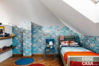 Nella cameretta azzurra del bambino, posata nella zona intorno al letto, la carta da parati riproduce un planisfero stilizzato Nella cameretta azzurra del bambino, posata nella zona intorno al letto, la carta da parati riproduce un planisfero stilizzato