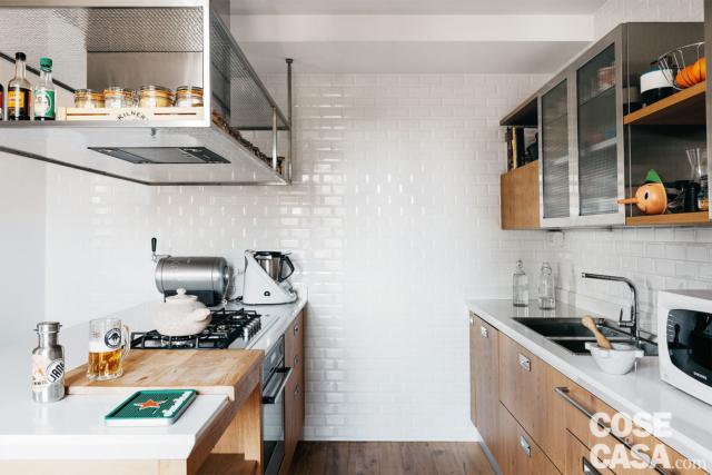 Il soffitto della cucina forma un "gradino" per passaggio degli impianti. La cappa in acciaio spazzolato è integrata in una struttura sospesa, sempre in acciaio. Il soffitto della cucina forma un "gradino" per passaggio degli impianti. La cappa in acciaio spazzolato è integrata in una struttura sospesa, sempre in acciaio.