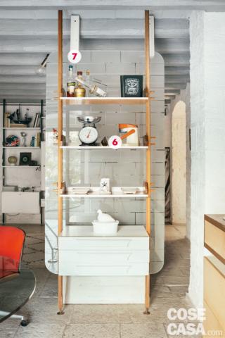 6. Revival anni '60
Sono numerosi nella casa di recupero, come abbiamo già avuto modo di osservare, i mobili di modernariato proposti nei diversi ambienti. Appartiene alla collezione anche la libreria a giorno completa di cassettiera fissata davanti alla quinta divisoria, ma completamente indipendente rispetto a essa. I due semplici montanti in legno che formano la struttura sono fissati sia a pavimento sia a soffitto. Lo stile della composizione è lo stesso della parte attrezzata in soggiorno, sulla parete di fianco al divano.
7. La quinta in vetro serigrafato
Il passaggio tra zona pranzo e living è segnato da una quinta verticale. Caratterizzata da bordi stondati, è in vetro sabbiato decorato con un motivo che richiama i mattoni in tufo dei muri dell'edificio. Il pannello è fissato in basso su un basamento in legno (la lastra scorre all'interno di un'apposita scanalatura) e anche in alto tramite due plinti sempre in legno verniciato bianco. 6. Revival anni '60
Sono numerosi nella casa di recupero, come abbiamo già avuto modo di osservare, i mobili di modernariato proposti nei diversi ambienti. Appartiene alla collezione anche la libreria a giorno completa di cassettiera fissata davanti alla quinta divisoria, ma completamente indipendente rispetto a essa. I due semplici montanti in legno che formano la struttura sono fissati sia a pavimento sia a soffitto. Lo stile della composizione è lo stesso della parte attrezzata in soggiorno, sulla parete di fianco al divano.
7. La quinta in vetro serigrafato
Il passaggio tra zona pranzo e living è segnato da una quinta verticale. Caratterizzata da bordi stondati, è in vetro sabbiato decorato con un motivo che richiama i mattoni in tufo dei muri dell'edificio. Il pannello è fissato in basso su un basamento in legno (la lastra scorre all'interno di un'apposita scanalatura) e anche in alto tramite due plinti sempre in legno verniciato bianco.