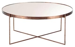 Dona luminosità al soggiorno il tavolino Comète di Maisons du Monde che ha la struttura in metallo ramato e il piano
a specchio tono su tono; misura Ø 83 x H 35 cm. Prezzo 199 euro.