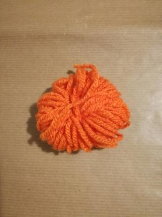 4.Fermate i due capi del filo di lana arancione sul retro della piccola zucca con una doppia annodatura, tagliate le parti eccedenti e modellate con cura la sagoma con le mani. 4.Fermate i due capi del filo di lana arancione sul retro della piccola zucca con una doppia annodatura, tagliate le parti eccedenti e modellate con cura la sagoma con le mani.