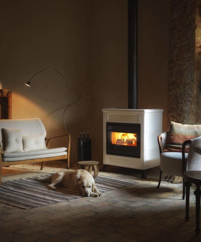 La stufa a legna Elsa di Palazzetti, dalla forma squadrata e rassicurante con piedini di ghisa e rivestimento di ceramica, nasconde un cuore tecnologico. Il focolare Ecopalex 66 T Glass, in Thermofix ad elevato spessore (cemento refrattario chiaro che ottimizza l’irraggiamento e migliora la combustione), si contraddistingue infatti per le prestazioni e i rendimenti. Una valvola automatica aumenta il tiraggio all’apertura della porta, in modo da evitare sbuffi di fumo verso l’esterno, e lo riduce alla chiusura, migliorando in tal modo anche la combustione ed enfatizzando la luminosità della fiamma. Inoltre, è possibile canalizzare l’ingresso dell’aria di post-combustione e regolarla con un dimmer. La stufa può scaldare più ambienti, canalizzando l’aria, consentendo distribuzione di calore fino a venti metri lineari complessivi. www.palazzetti.it La stufa a legna Elsa di Palazzetti, dalla forma squadrata e rassicurante con piedini di ghisa e rivestimento di ceramica, nasconde un cuore tecnologico. Il focolare Ecopalex 66 T Glass, in Thermofix ad elevato spessore (cemento refrattario chiaro che ottimizza l’irraggiamento e migliora la combustione), si contraddistingue infatti per le prestazioni e i rendimenti. Una valvola automatica aumenta il tiraggio all’apertura della porta, in modo da evitare sbuffi di fumo verso l’esterno, e lo riduce alla chiusura, migliorando in tal modo anche la combustione ed enfatizzando la luminosità della fiamma. Inoltre, è possibile canalizzare l’ingresso dell’aria di post-combustione e regolarla con un dimmer. La stufa può scaldare più ambienti, canalizzando l’aria, consentendo distribuzione di calore fino a venti metri lineari complessivi. www.palazzetti.it