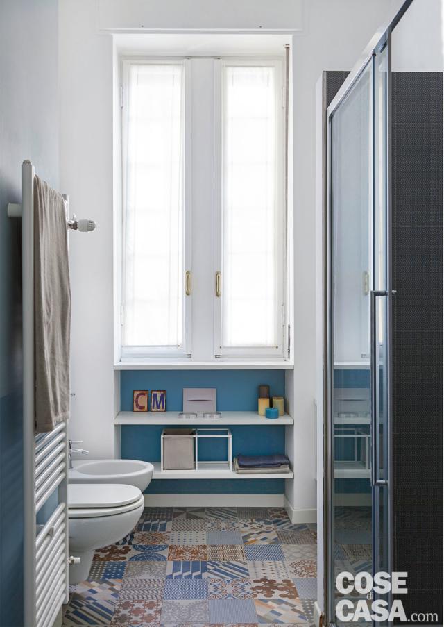 bagno con piastrelle cementine sull'azzurro, mensole sottofinestra casa in stile nordico bagno con piastrelle cementine sull'azzurro, mensole sottofinestra casa in stile nordico