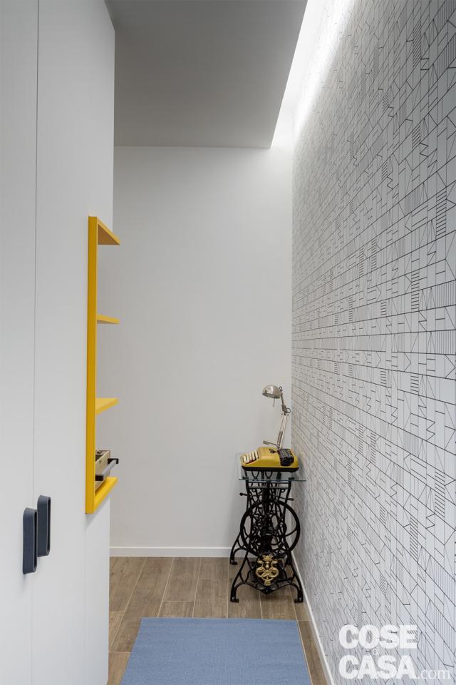 ingresso, armadiatura, parete rivestita con carta da parati, nicchia, taglio luminoso nel controsoffitto, base di un'antica macchina per cucire nell'angolo ingresso, armadiatura, parete rivestita con carta da parati, nicchia, taglio luminoso nel controsoffitto, base di un'antica macchina per cucire nell'angolo