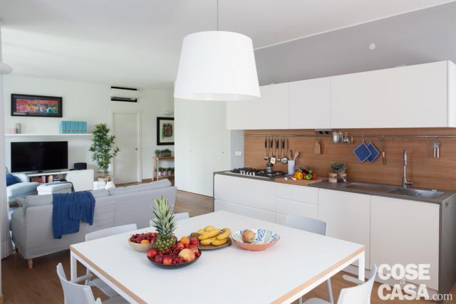 open space con soggiorno, zona pranzo con tavolo quadrato in laccato bianco, cucina a vista con alzata in rovere , zona cottura, lavello e pensili open space con soggiorno, zona pranzo con tavolo quadrato in laccato bianco, cucina a vista con alzata in rovere , zona cottura, lavello e pensili