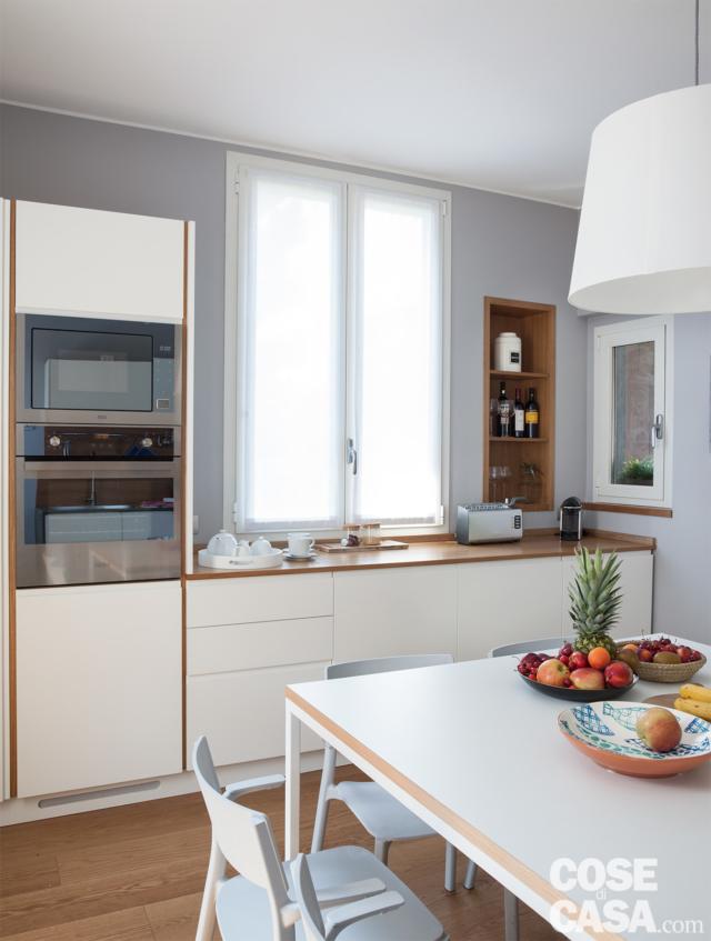 cucina in linea con zona cottura e lavaggio, finestre, zona pranzo con tavolo quadrato a otto posti a centro stanza cucina in linea con zona cottura e lavaggio, finestre, zona pranzo con tavolo quadrato a otto posti a centro stanza